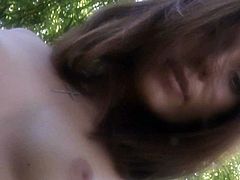 Nataly Von is lasciviously stripping off her clothes next to a tree, outdoors. She touches her pussy softly.