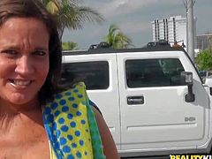 Brunette nest door in sexy bikini is busty and cash hungry. She pulls out her huge round tits for money. This beach girl demonstrates her lovely fake boobs in a car playfully.