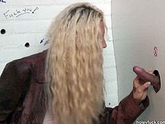 This frizzy blondie with big boobs and slim tanned body is in WC. She's already pissed and just noticed a strong dick jutting out of the glory hole. Without any hesitation kinky chick squats down to give a solid blowjob right away.
