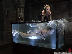 Chubby chick Star lets some girl bind her and smash her vag with a dildo. Then she gets sunk into a glass box with water and gets cooled.