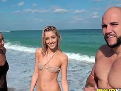 Two luscious babes (brunette and blond) hook up with a horny bald dude at they beach. They swim with him in the ocean wearing steamy bikini before he invites them over at his place.