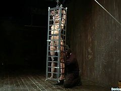 Yasmine doesn't needs to much space to move because all she needs to do is endure what her executor does with her sexy body. The hot brunette is immobilized in that small bondage cage and the guy fucks her ass with a dildo between the bars. Yeah, that's exactly what she deserves for the warm up. Wanna see more?