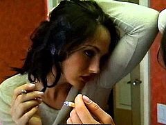 Sexy brunette likes to pose her hairy cunt while smoking and teasing