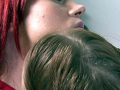 These two sexy redheads enjoy a nice make out session. One is a natural redhead and the other is a redhead with a dye job. They kiss each other hard in the living room and run their tongues over each other's lips.