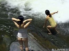 Two salacious Japanese girls are playing lesbian games outdoors. They kiss and pet each other in a pond and then demonstrate their pussy-licking skills.