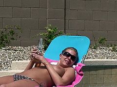 Busty blonde bombshell Riley Evans takes a sun bath