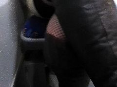 Girl in fishnet stockings and black leather boots in a bus