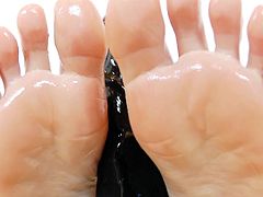 Jennifer is about to show us some feet love. She oils up her sexy feet and then, starts to slide them on that big black dildo. Yeah, she's doing it like a bad girl and feels horny at the thought, that it could be a real hard cock. Who knows, maybe she will receive a dick between her oiled feet!