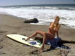 Curvaceous Stormy Daniels poses for the camera on the beach. After some time she takes a bikini off and starts to rub her shaved pussy.
