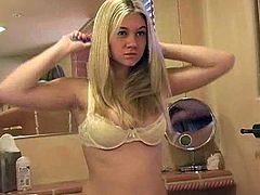 Superb blonde babe with perfect boobs makes a solo show in the bathroom. This angelic girl also brushes her hair and dresses on a bra.
