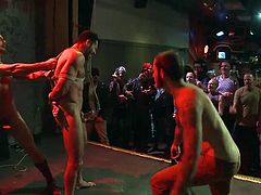 In this gay bar everybody's having fun, except Billy. Billy can't enjoy himself too much because he's being tied up and offered to the public. When he's brought on the stage, completely naked and all tied, the boys go crazy! They cheer him and then begin to fuck the hot brunette sex slave's mouth.