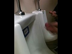 two slim dicks getting wanked at the urinals