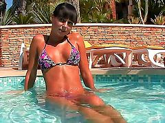 Beautiful dark haired babe Carie looks so lovely as she sits in the outdoor swimming pool in just her very small bikini. Imagine your hands holding those big firm titties of hers and your hand sliding right under her panties and feeling her tight young pussy.