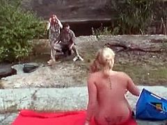 Granny was out with grandpa, who was fishing. A teen girl came and started to sunbathe topless. Grandpa got horny, so grandma sucked on his cock while the teen girl watched them.