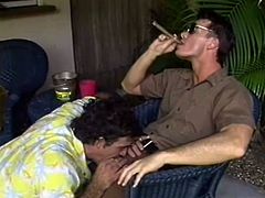 A dude smokes a cigar while getting his dick sucked in gay clip