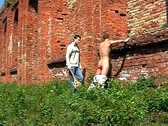 Two gays have fun in the territory of some abandoned factory. One of the guys pulls his pants down and gets whipped by another dude. After that he starts to stroke his large dick.