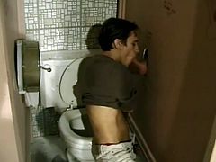 A kinky gay blows a dick greedily in a gloryhole toilet. Then he takes his pants off and also gets butt fucked.