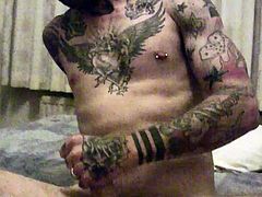 Tattoeed stud with random piercing on his body getting horny as he took his huge dick stroke it and jacking it off til he releases her fresh hot load right on his body.