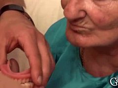 This European granny takes out her dental prosthesis and sucks on two cocks. She also reveals her huge natural boobs before she gets face-fucked some more.