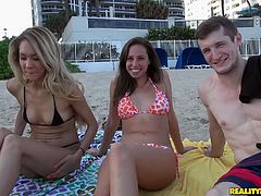 Press play to watch this reality video where two babes, with nice butts wearing bikinis, go hardcore with a dude in a FFM after having fun at the beach.