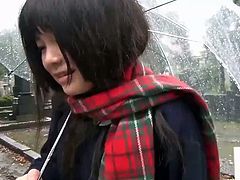 This Japanese schoolgirl has a toy in her panties. She walks through a cemetery and flashes her panties and the vibrator that stimulates her pussy while holding an umbrella.