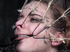 Jessica is in a very unique situation here. The young, beautiful, metal-mouthed slut is in an big oil drum with only her head exposed. Her executors have hooks attached to wires, which they are putting in her mouth, stretching and pulling her lips and nose. They also use a pair of tongs to pull her tongue.