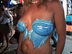 Youll see one chic whos not wearing any panties, squatting down to spread open her hairy pussy lips. Next, an older couple pauses, so the wife can show off her hooters, along with several more great knockers, that are painted.