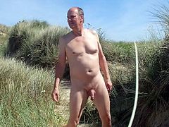 Male nudist dancing naked & free in the beach dunes.